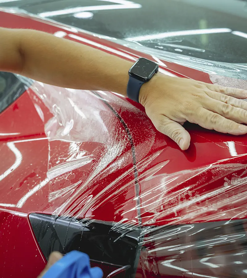 Aplicación de PPF en carrocería de coche rojo en Valencia